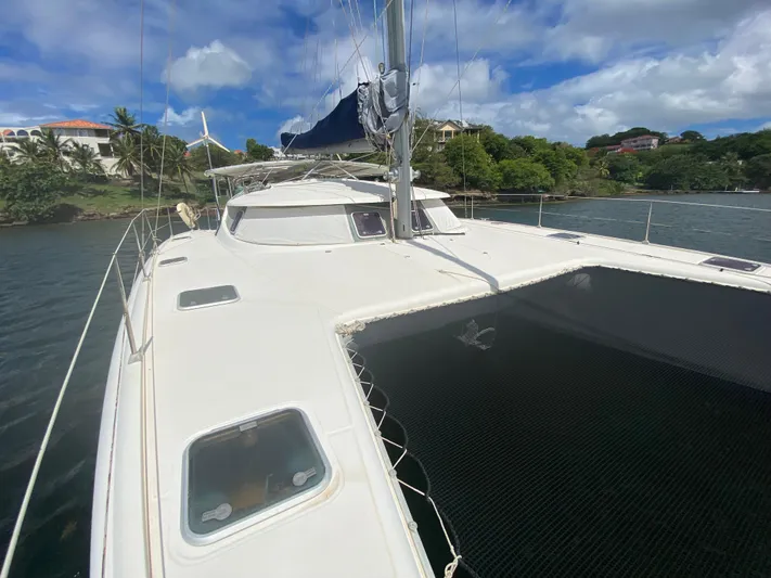 Certitude Yacht Photos Pics 1998 Fountaine Pajot Bahia 46 catamaran docked near lush shoreline under blue sky.