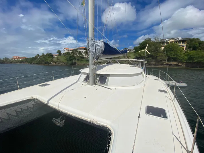 Certitude Yacht Photos Pics 1998 Fountaine Pajot Bahia 46 catamaran on calm waters, with scenic coastal backdrop.