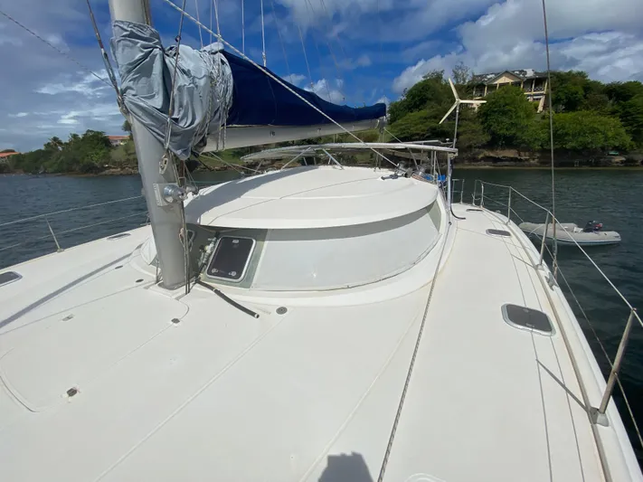 Certitude Yacht Photos Pics 1998 Fountaine Pajot Bahia 46 catamaran docked by lush green shoreline.