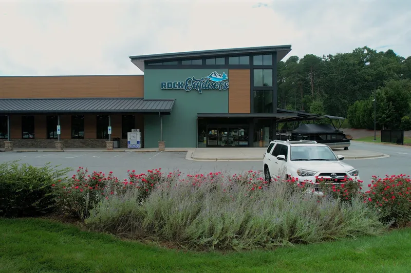  Yacht Photos Pics Outdoor store with a Barletta Lusso 23UCA boat and white SUV in the parking lot.