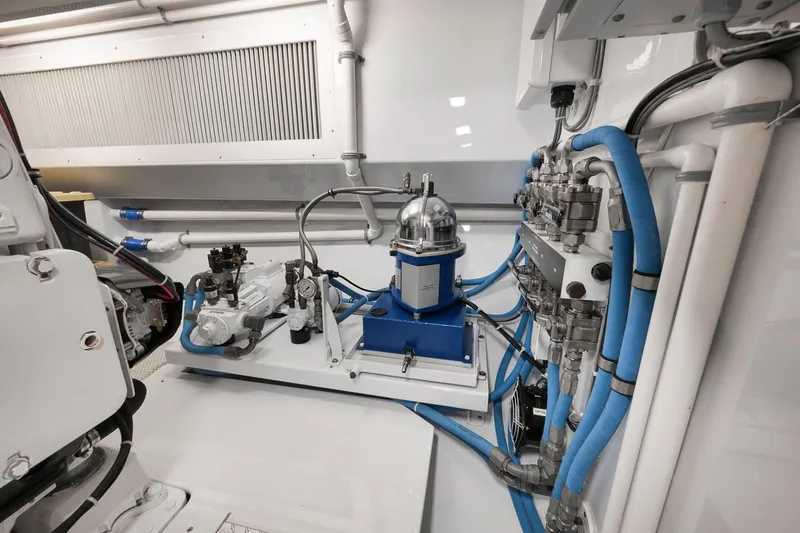 Artemis Yacht Photos Pics Engine room of 2020 Merritt 77 Sportfish Convertible with advanced machinery and blue piping.