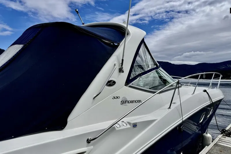  Yacht Photos Pics 2008 Sea Ray 330 Sundancer yacht docked by a scenic lake under a cloudy sky.