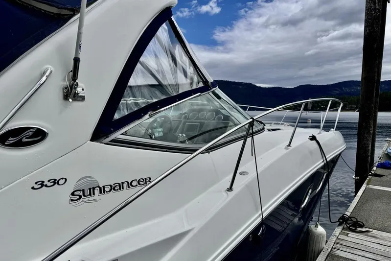  Yacht Photos Pics 2008 Sea Ray 330 Sundancer yacht docked by a scenic lake under cloudy skies.