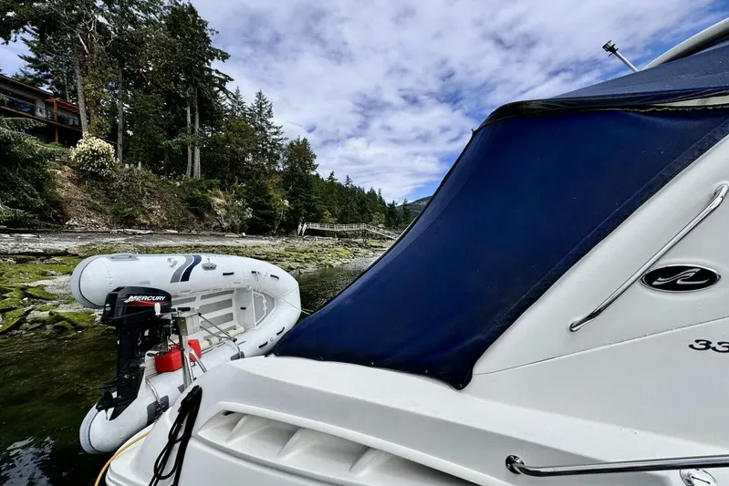  Yacht Photos Pics 2008 Sea Ray 330 Sundancer docked with inflatable boat, surrounded by lush forest.