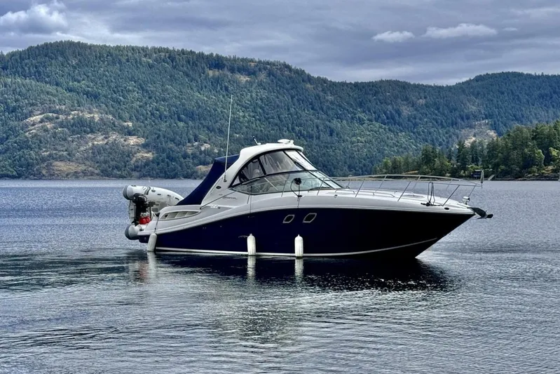  Yacht Photos Pics 2008 Sea Ray 330 Sundancer yacht on a serene lake with forested hills.