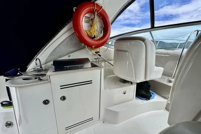  Yacht Photos Pics 2008 Sea Ray 330 Sundancer interior with seating, life preserver, and kitchenette under blue sky.