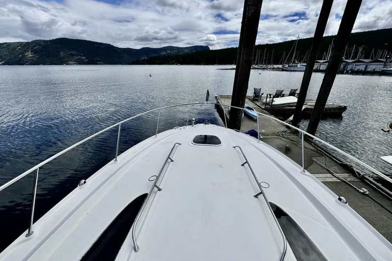  Yacht Photos Pics 2008 Sea Ray 330 Sundancer docked at a scenic marina with mountains in the background.