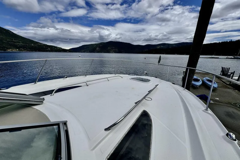  Yacht Photos Pics 2008 Sea Ray 330 Sundancer yacht on serene lake with mountainous backdrop.