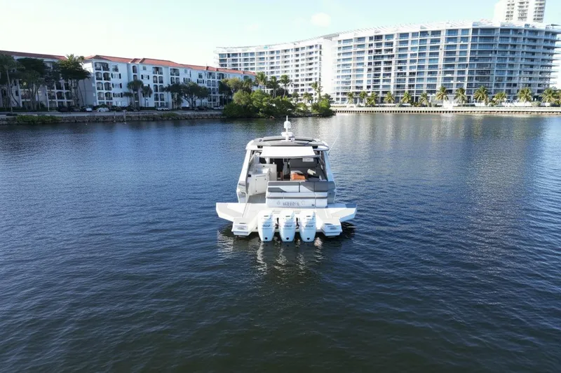  Yacht Photos Pics 2021 Cruisers Yachts 42 GLS OB on calm water near waterfront buildings.