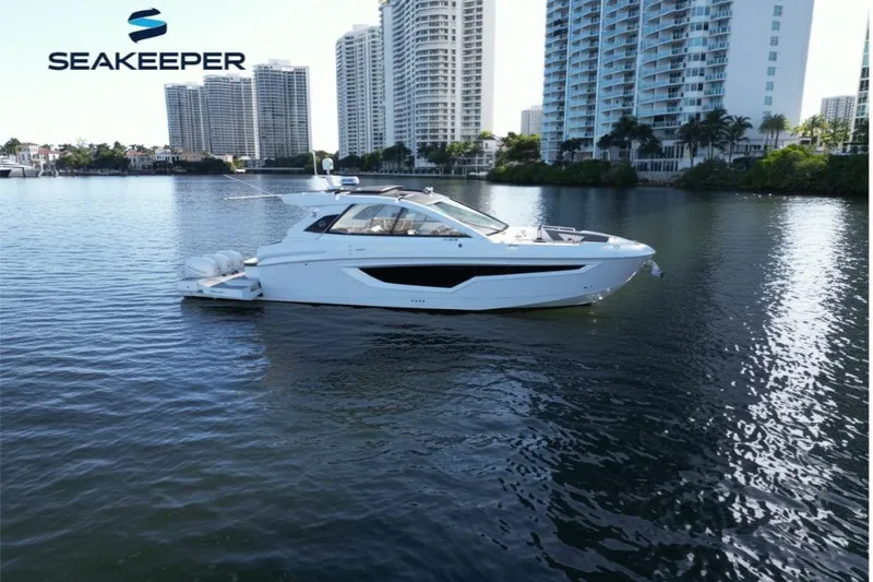  Yacht Photos Pics 2021 Cruisers Yachts 42 GLS OB on water, city skyline in background.