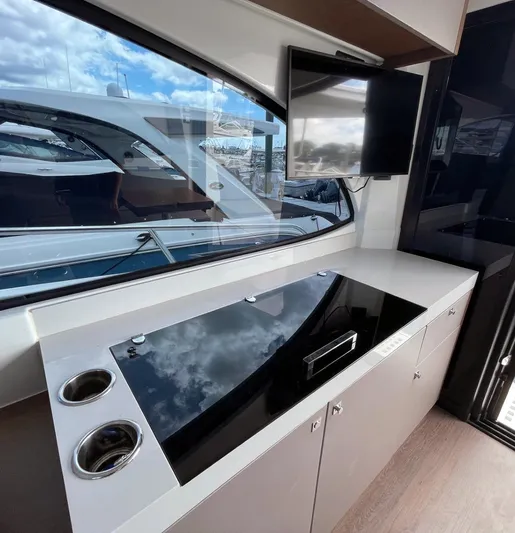 Rub A Dub Yacht Photos Pics Modern kitchen area on 2023 Beneteau Antares 11 OB yacht with sleek countertop and window view.