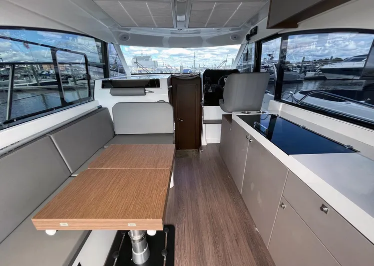 Rub A Dub Yacht Photos Pics Interior of 2023 Beneteau Antares 11 OB, featuring seating, table, and helm station.