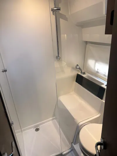 Rub A Dub Yacht Photos Pics Modern bathroom interior of 2023 Beneteau Antares 11 OB boat, featuring shower and toilet.