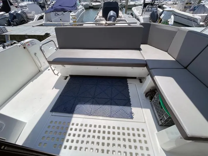 Rub A Dub Yacht Photos Pics 2023 Beneteau Antares 11 OB boat deck with gray seating and blue mat.