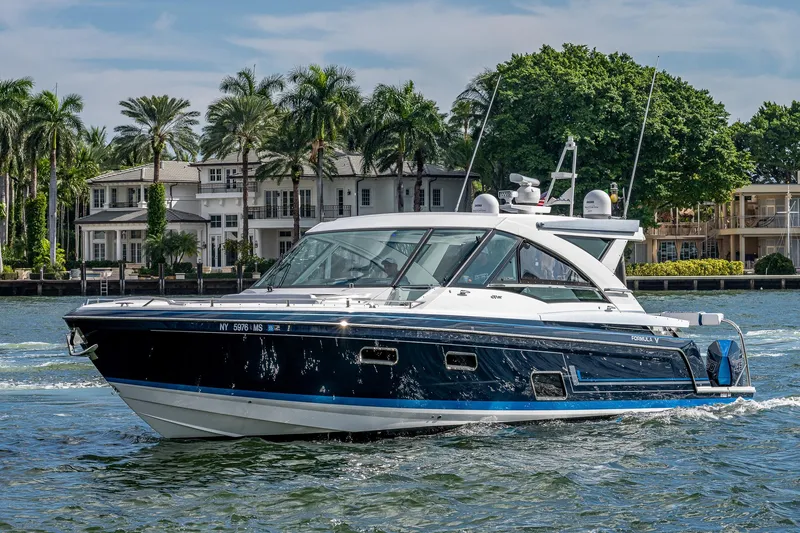 Yacht Photos Pics 2022 Formula 430 SSC yacht cruising on a scenic waterway with luxury homes in the background.