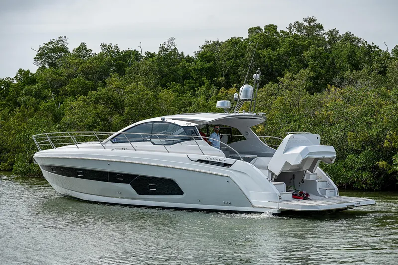  Yacht Photos Pics 2021 Azimut Atlantis 45 yacht cruising near lush green shoreline.