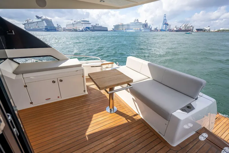 Man Cave Yacht Photos Pics 2021 Maritimo X50 yacht deck with seating, overlooking a busy harbor with cruise ships.