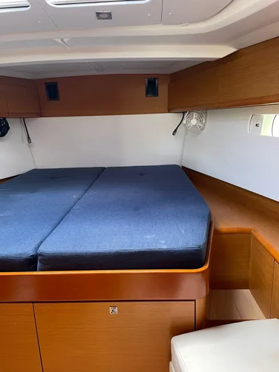 Hygge Yacht Photos Pics Interior cabin of 2017 Jeanneau Sun Odyssey 479 with blue cushions and wooden finish.