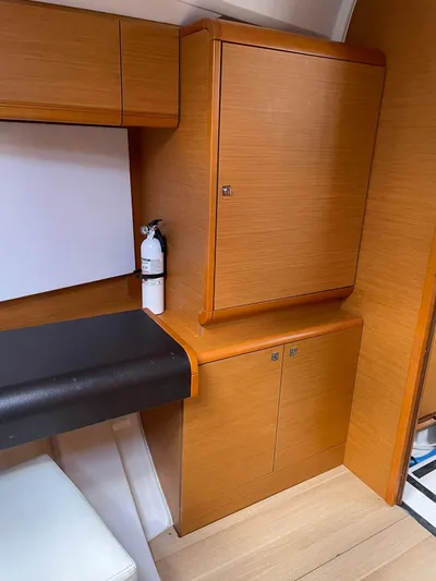 Hygge Yacht Photos Pics 2017 Jeanneau Sun Odyssey 479 interior with wooden cabinetry and seating area.