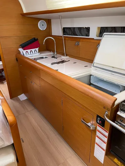 Hygge Yacht Photos Pics 2017 Jeanneau Sun Odyssey 479 yacht kitchen with wooden cabinetry and modern appliances.