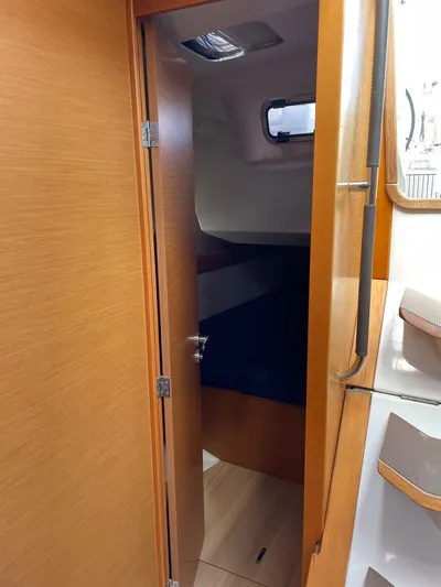 Hygge Yacht Photos Pics Interior cabin of 2017 Jeanneau Sun Odyssey 479 sailboat, featuring wooden door and cozy sleeping area.