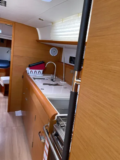 Hygge Yacht Photos Pics 2017 Jeanneau Sun Odyssey 479 yacht interior kitchen with wooden cabinetry and modern fixtures.