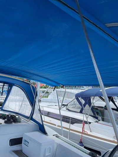 Hygge Yacht Photos Pics 2017 Jeanneau Sun Odyssey 479 sailboat with blue canopy docked at marina.