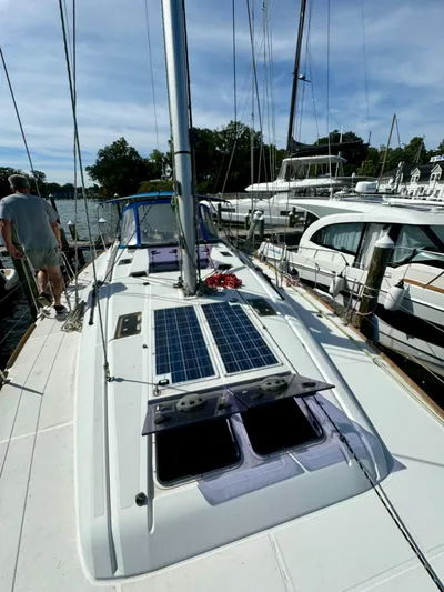 Hygge Yacht Photos Pics 2017 Jeanneau Sun Odyssey 479 sailboat with solar panels, docked at a marina.