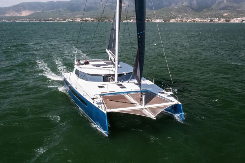 Ondine Blue Yacht Photos Pics Sailing catamaran Balance 526, 2016 model, cruising on open water with scenic mountain backdrop.