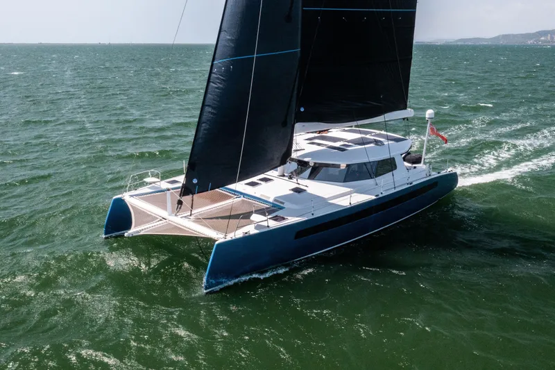 Ondine Blue Yacht Photos Pics Sleek 2016 Balance 526 catamaran sailing on open sea with black sails.