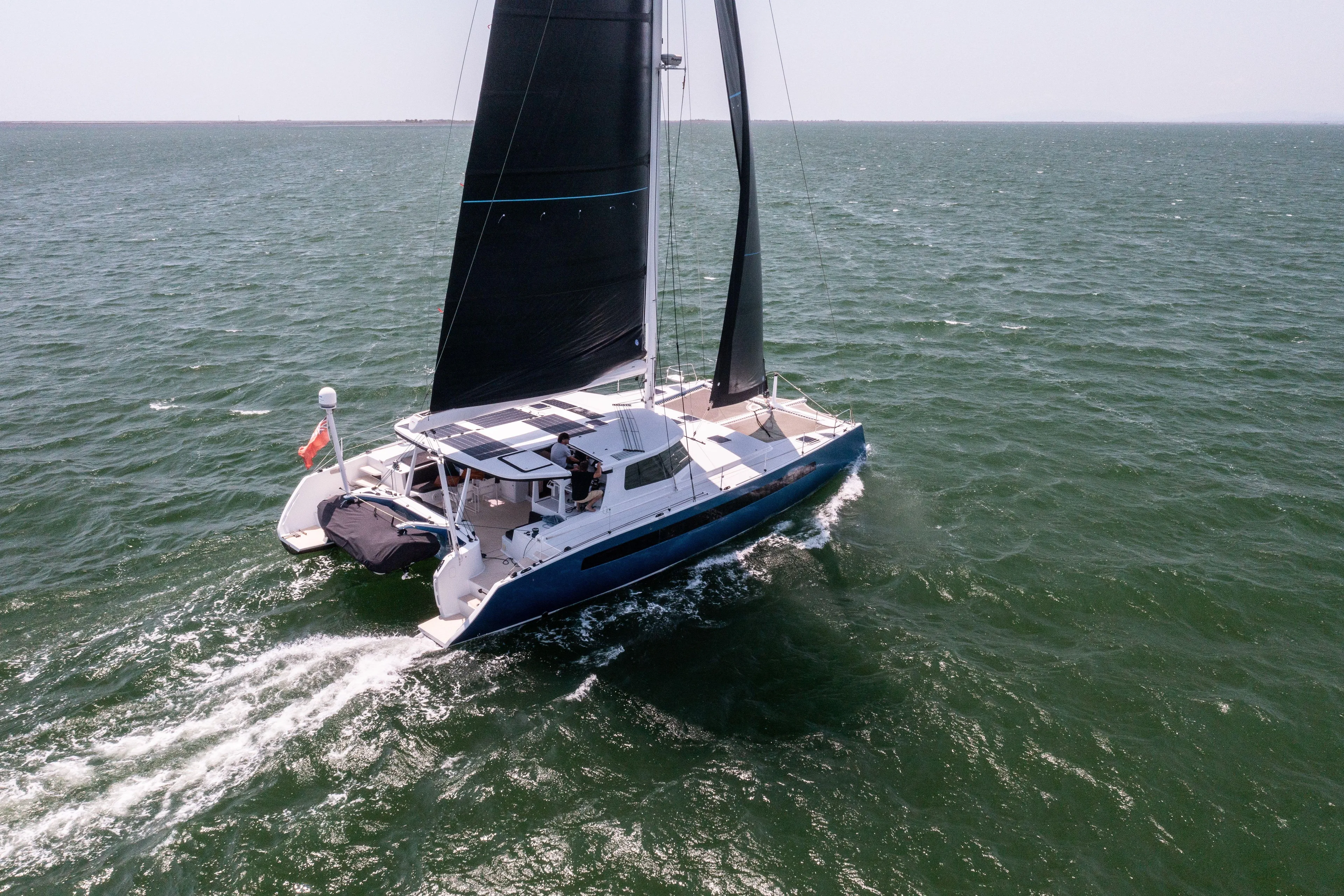 Ondine Blue Yacht Photos Pics Sailing catamaran Balance 526 (2016) gliding on open sea with black sails.