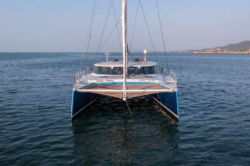 Ondine Blue Yacht Photos Pics Front view of a 2016 Balance 526 catamaran sailing on calm waters.