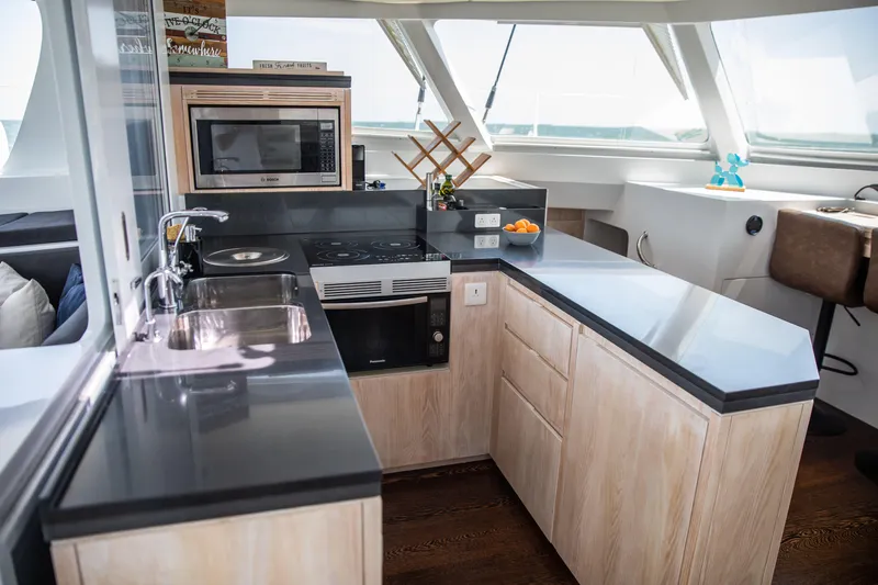 Ondine Blue Yacht Photos Pics Modern yacht kitchen interior with sleek countertops, microwave, and sink, Balance 526 model, 2016.