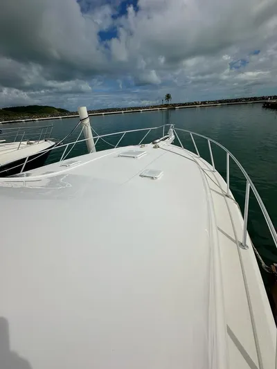  Yacht Photos Pics 2002 Bertram 510 Convertible yacht docked at a marina under cloudy skies.