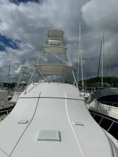  Yacht Photos Pics 2002 Bertram 510 Convertible yacht with a tower, docked at a marina.