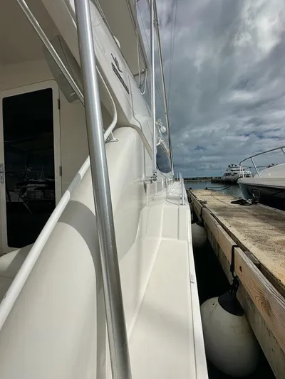  Yacht Photos Pics 2002 Bertram 510 Convertible yacht docked at marina under cloudy sky.