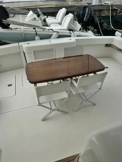 Yacht Photos Pics 2002 Bertram 510 Convertible yacht deck with table and chairs.