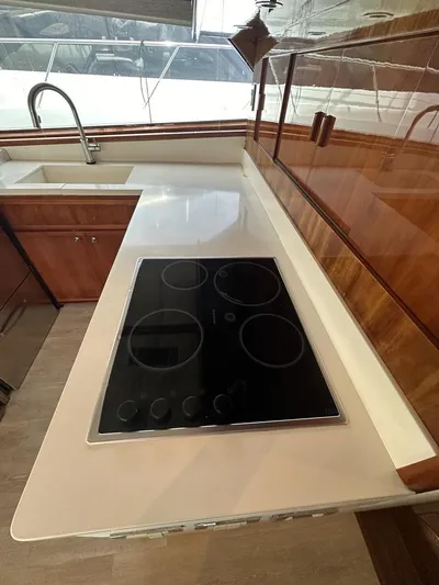  Yacht Photos Pics Modern kitchen area in a 2002 Bertram 510 Convertible yacht with electric cooktop and sink.