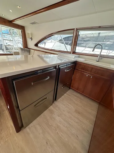  Yacht Photos Pics 2002 Bertram 510 Convertible yacht kitchen with modern appliances and wooden cabinetry.