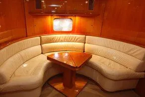  Yacht Photos Pics Luxurious interior of 2000 Uniesse 57 yacht with elegant leather seating and wooden table.