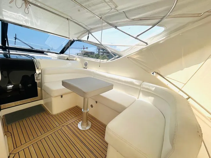  Yacht Photos Pics Luxurious interior of 2000 Uniesse 57 yacht with white seating and wooden flooring.