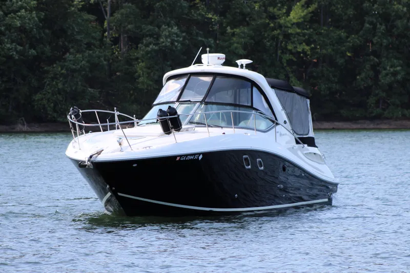  Yacht Photos Pics 2008 Sea Ray 330 Sundancer cruising on a serene lake with lush forest backdrop.