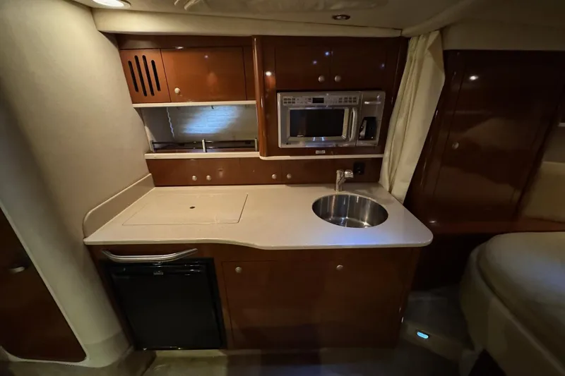  Yacht Photos Pics 2008 Sea Ray 330 Sundancer interior kitchen with sink, microwave, and compact fridge.