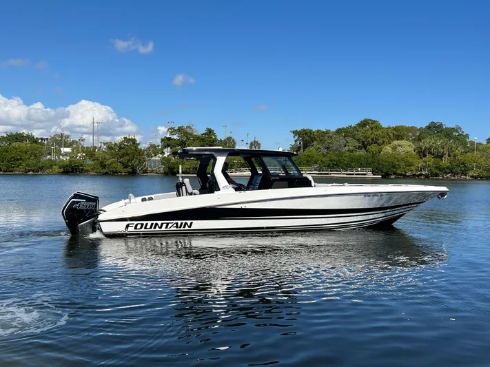  Yacht Photos Pics 2023 Fountain 38 SCX boat on calm water under clear blue sky.