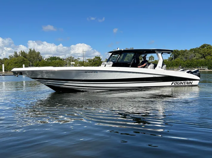  Yacht Photos Pics 2023 Fountain 38 SCX boat on calm water, clear sky background.