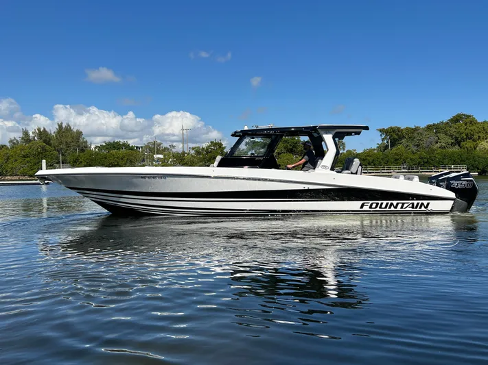  Yacht Photos Pics 2023 Fountain 38 SCX boat on calm water under clear blue sky.