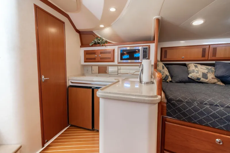 Miss Big Gun Yacht Photos Pics Interior of 2000 Cabo 35 Express yacht with kitchenette and cozy sleeping area.