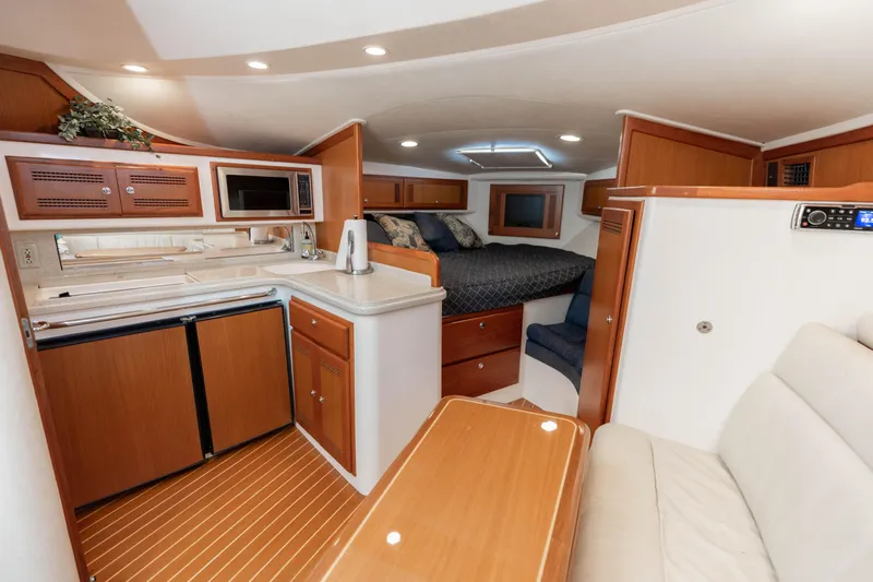 Miss Big Gun Yacht Photos Pics Interior of 2000 Cabo 35 Express yacht with kitchen, seating, and sleeping area.