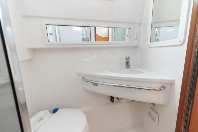 Miss Big Gun Yacht Photos Pics Compact bathroom in 2000 Cabo 35 Express boat with sink and toilet.