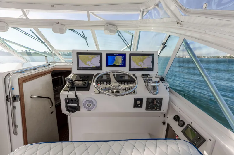 Miss Big Gun Yacht Photos Pics Helm of 2000 Cabo 35 Express boat with navigation screens and steering wheel.